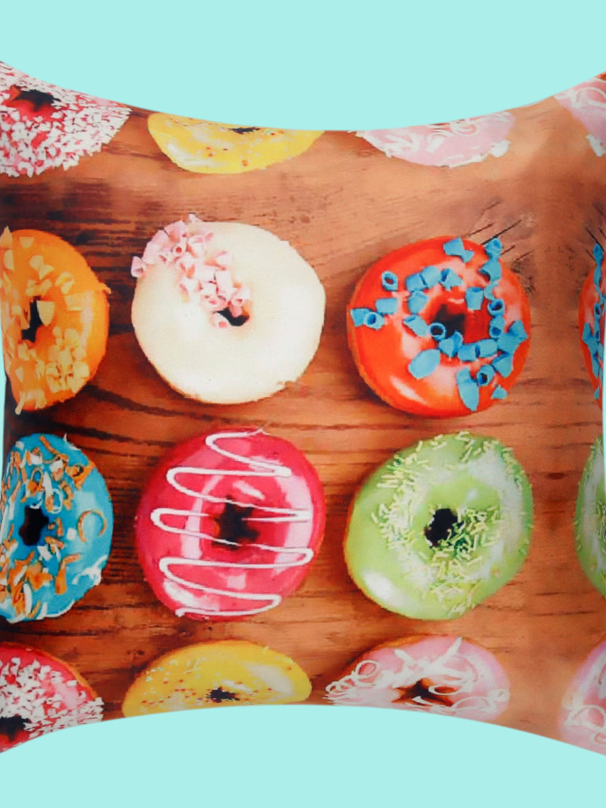 Cushion cover printed with iced doughnuts in bright colours on a wooden background