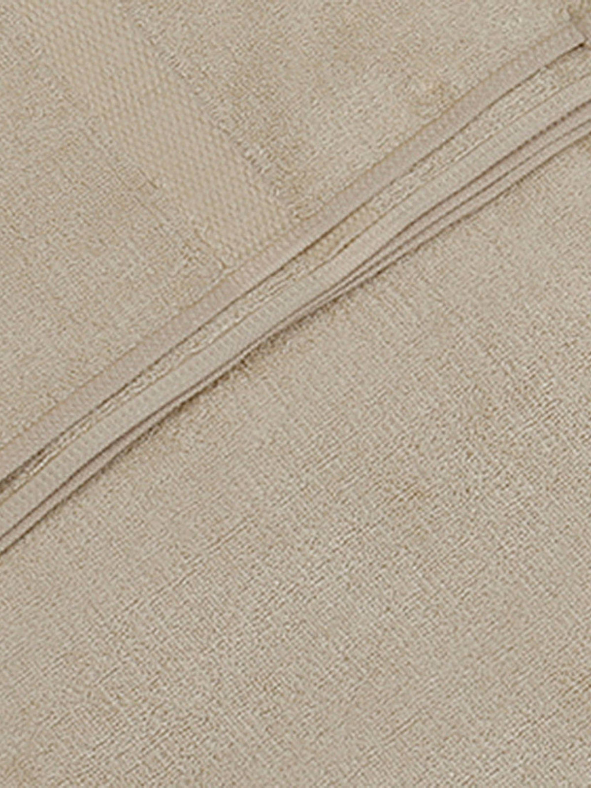 Close-up of fawn beige bamboo bath towel fabric texture with a folded edge