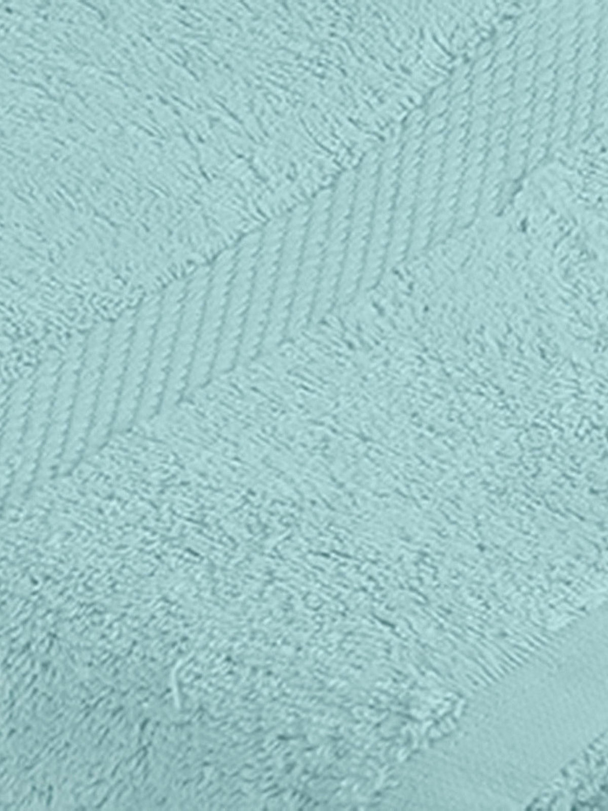 Pale sky-blue cotton bath towel folded flat with a herringbone woven border, close angle
