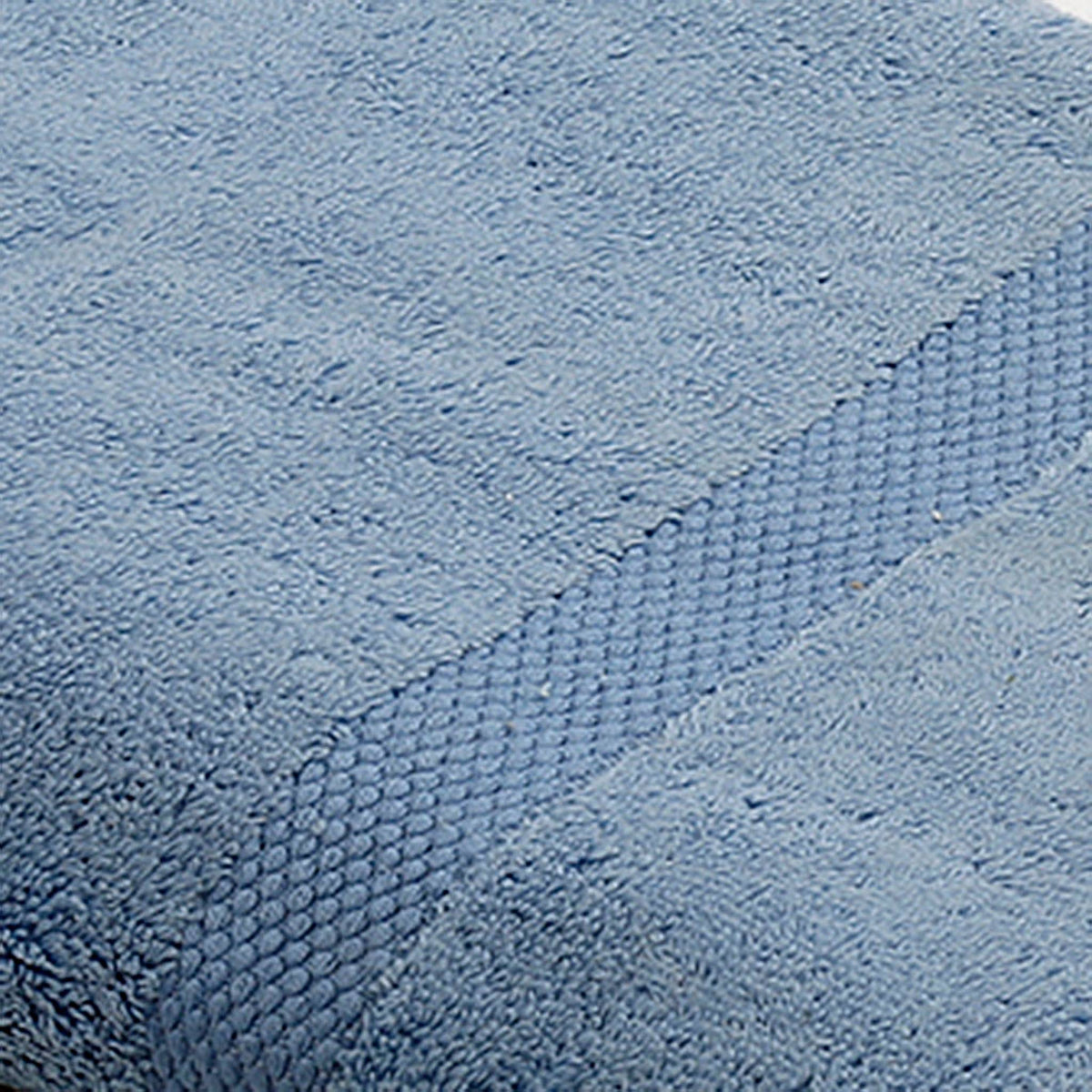 Close-up of light blue cotton bath towel folded, showing the honeycomb woven border texture
