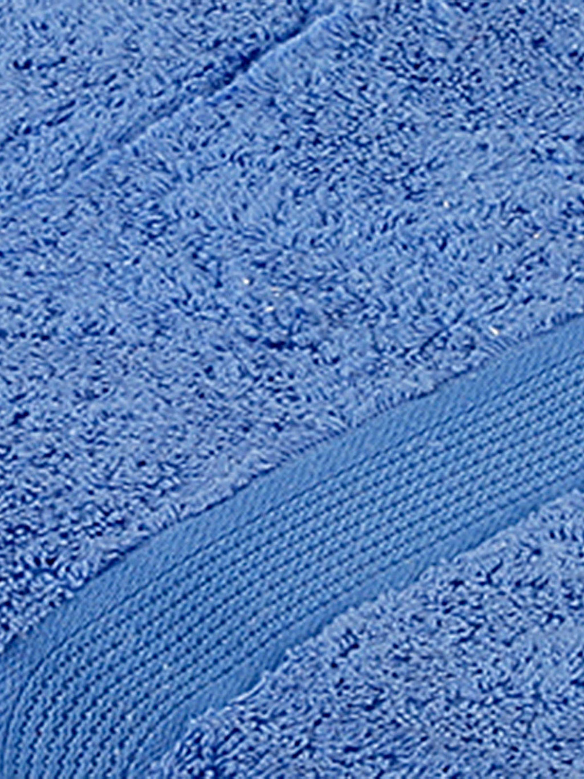 Close-up of cornflower-blue cotton bath towel folded, showing the ribbed woven border texture