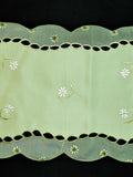 Green embroidered table mat close-up embroidery stitch detail