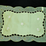 Green embroidered table mat close-up embroidery stitch detail