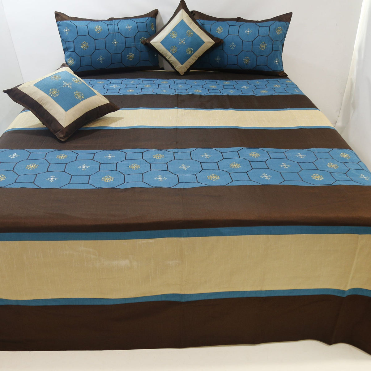 Blue and brown striped dupion silk bedcover with matching pillow covers and cushions on a bed