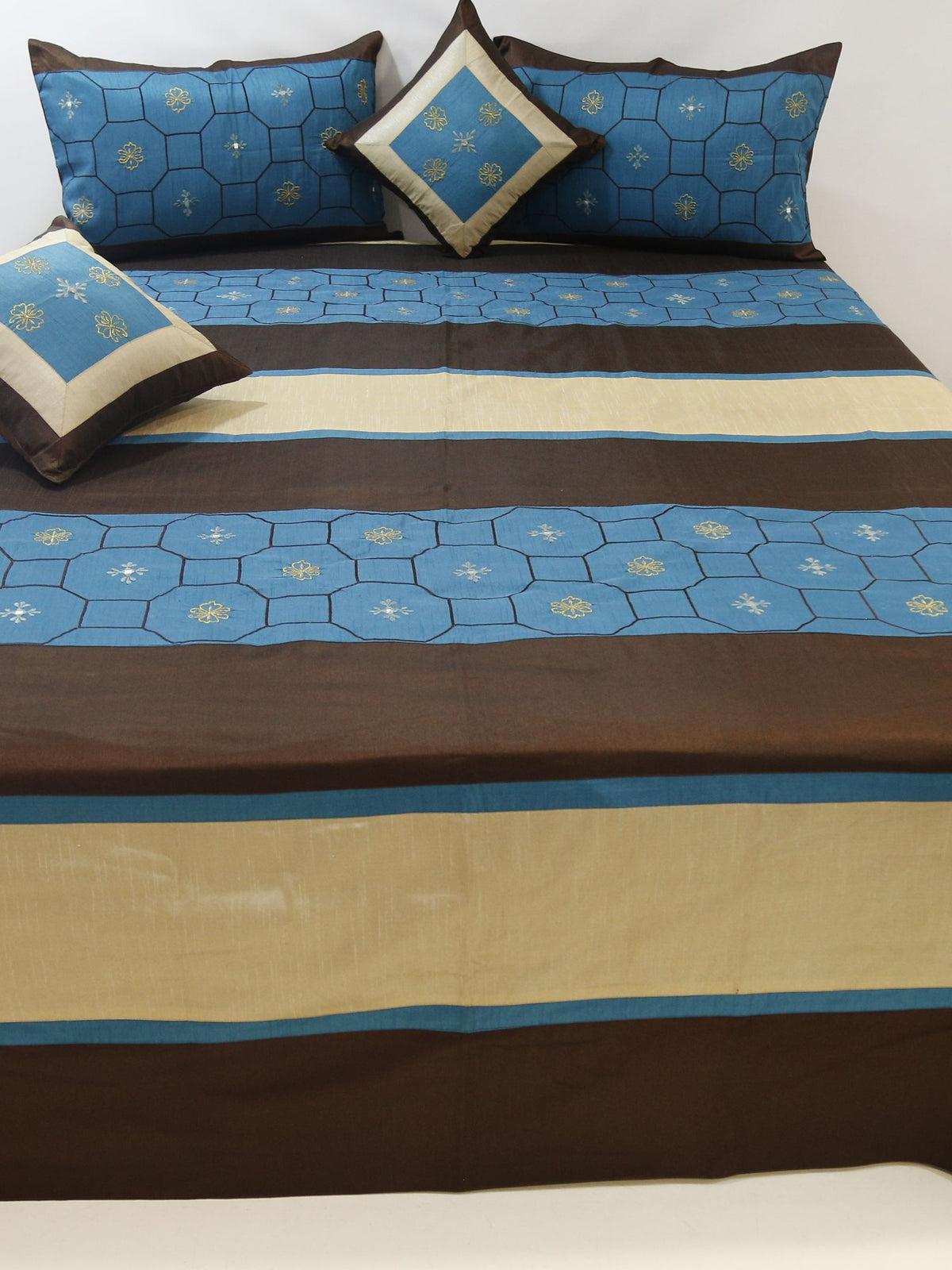 Blue and brown striped dupion silk bedcover with matching pillow covers and cushions on a bed