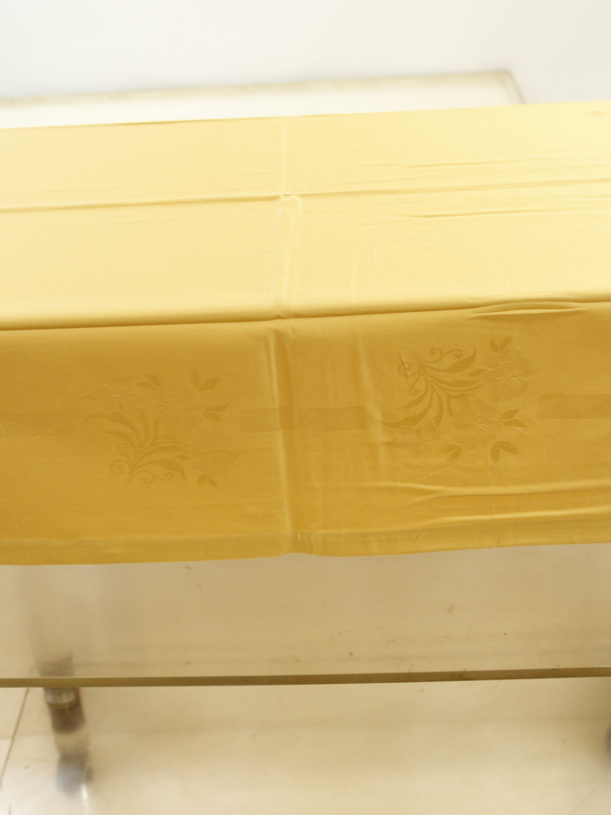Pale gold self-jacquard table cover with a tone-on-tone floral damask pattern