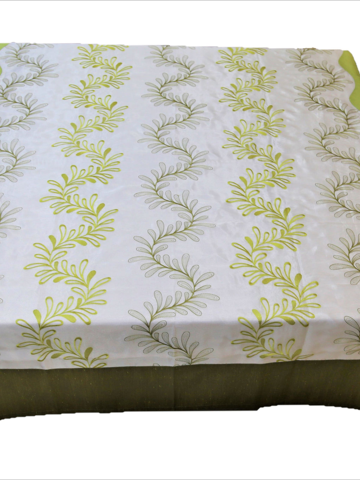 White table cover with a green embroidered fern-leaf pattern and a solid olive-green underskirt