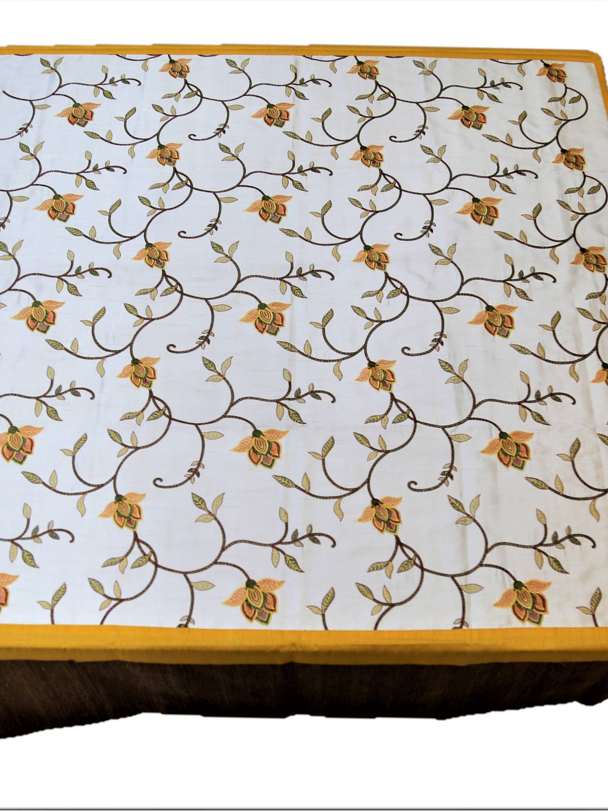 White table cover with a multicolour embroidered floral vine pattern, a gold trim, and a solid brown underskirt