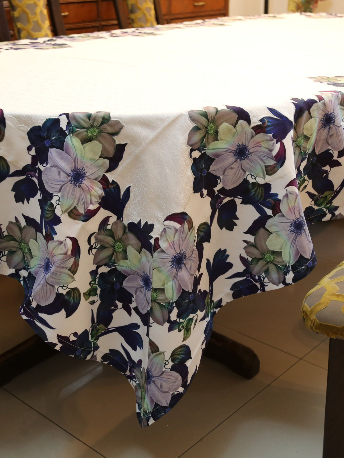 White oval table cover with a printed navy, purple, and green floral border pattern