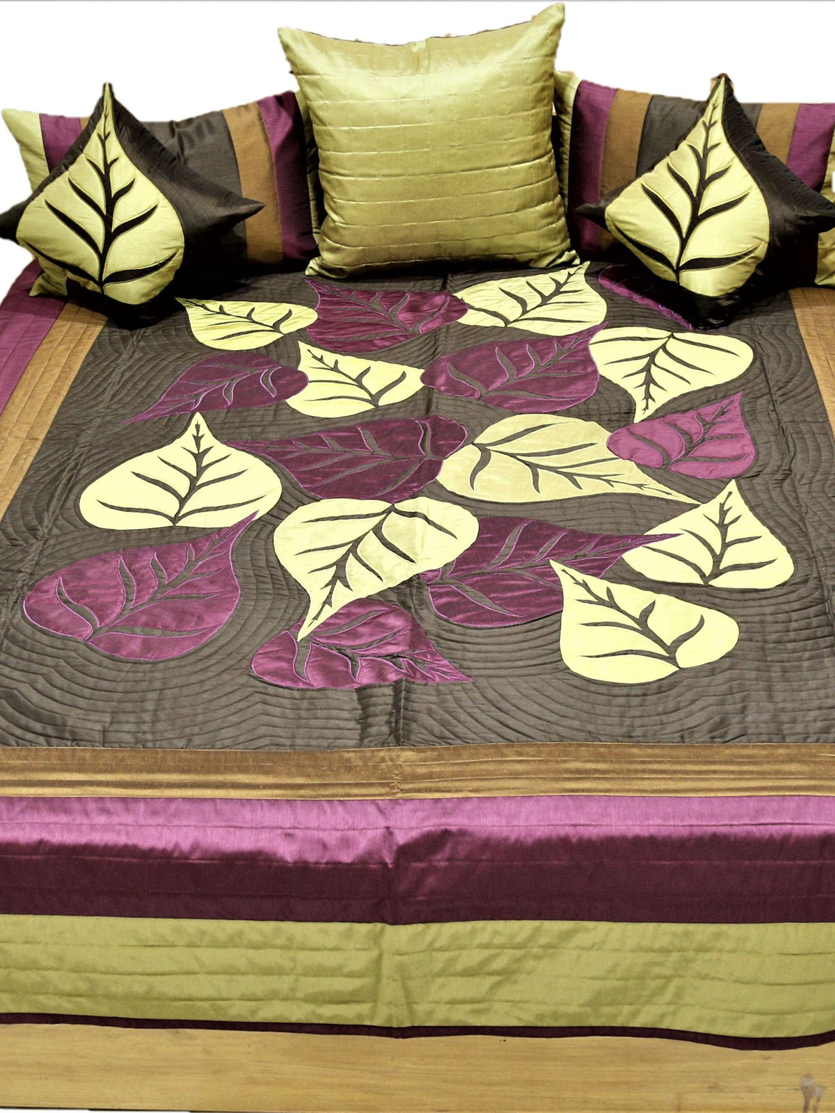 Leaf applique bedcover flat view with olive, gold and aubergine border and leaf cushions