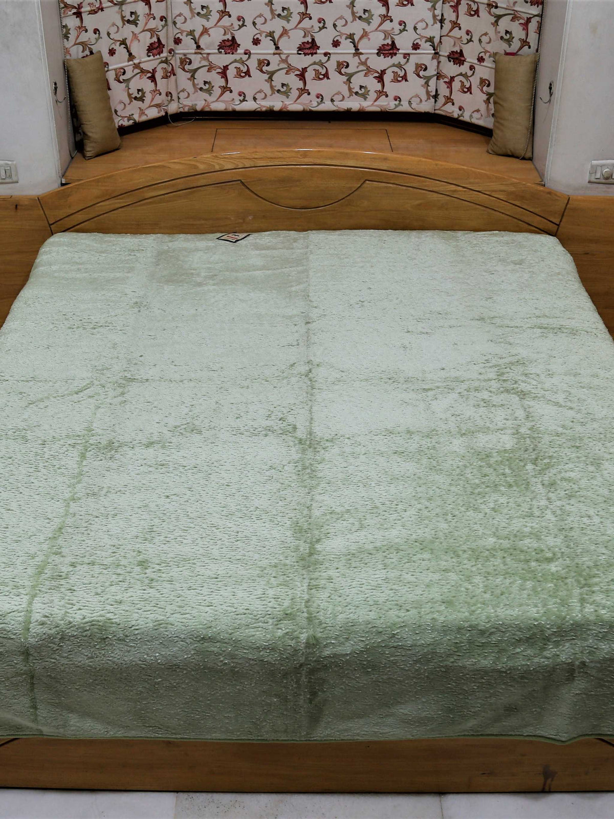 Pale sage green Monaco blanket seen square on across a double bed