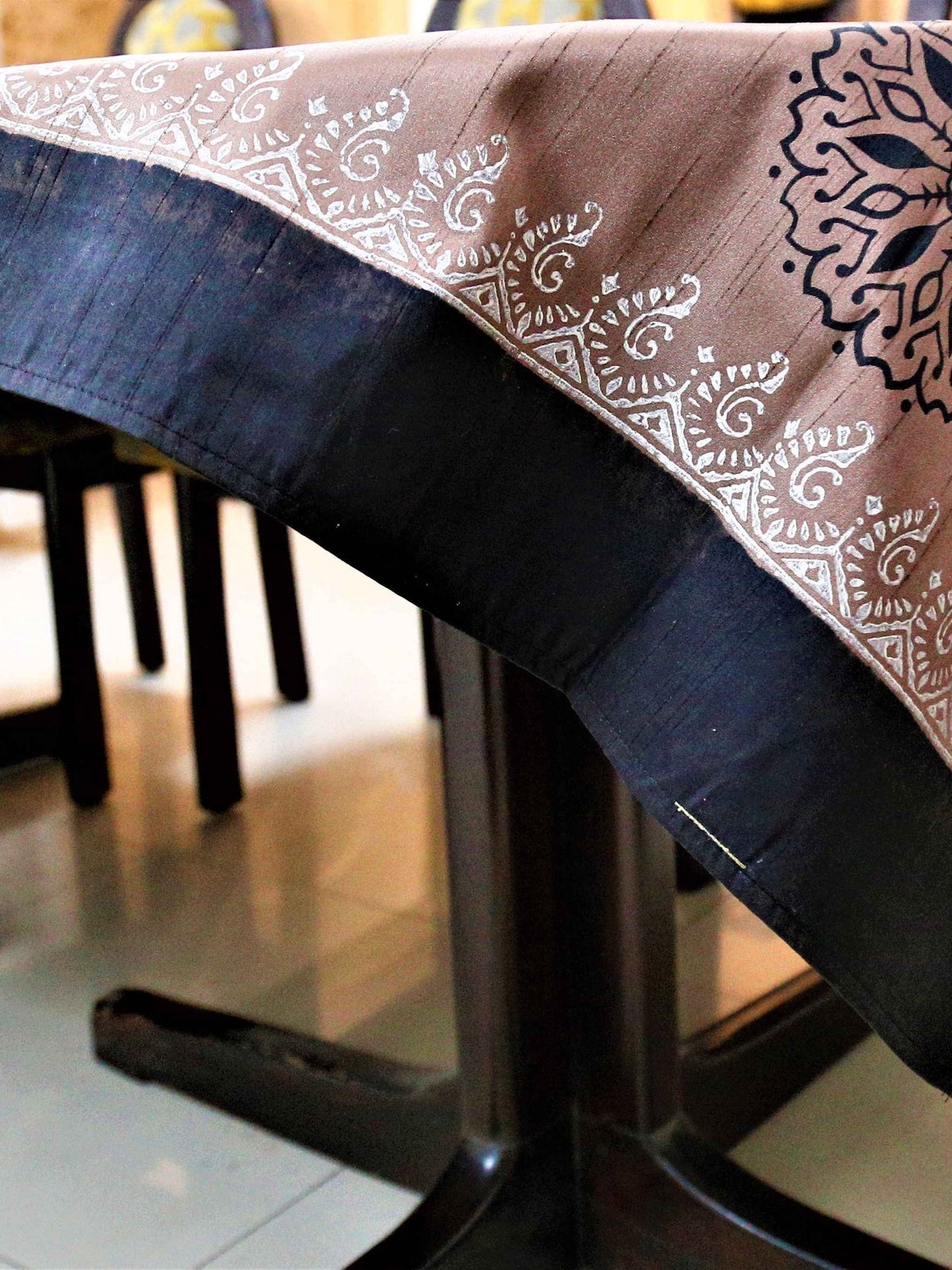 Dusty pink-brown table cover with a black and white block-printed mandala medallion pattern and a black lace-trimmed border