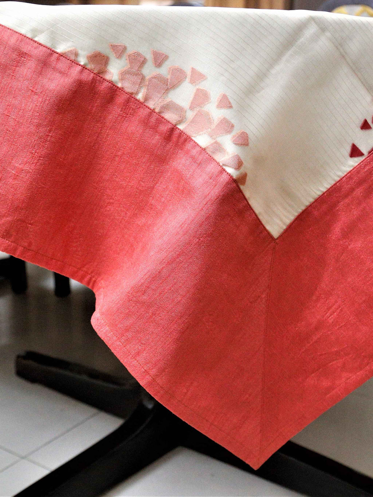 Cream table cover with a cutwork circular floral medallion pattern and a solid gajri-red border