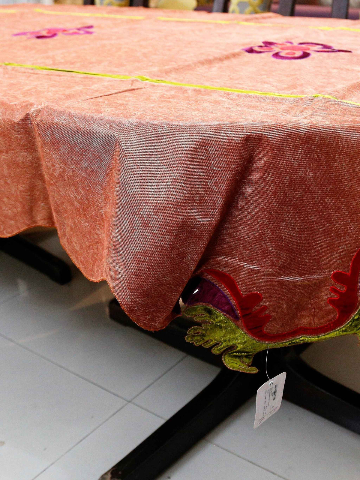 Rust-orange velvet-look table cover with purple and pink flower appliqué motifs and a lime-green piped seam