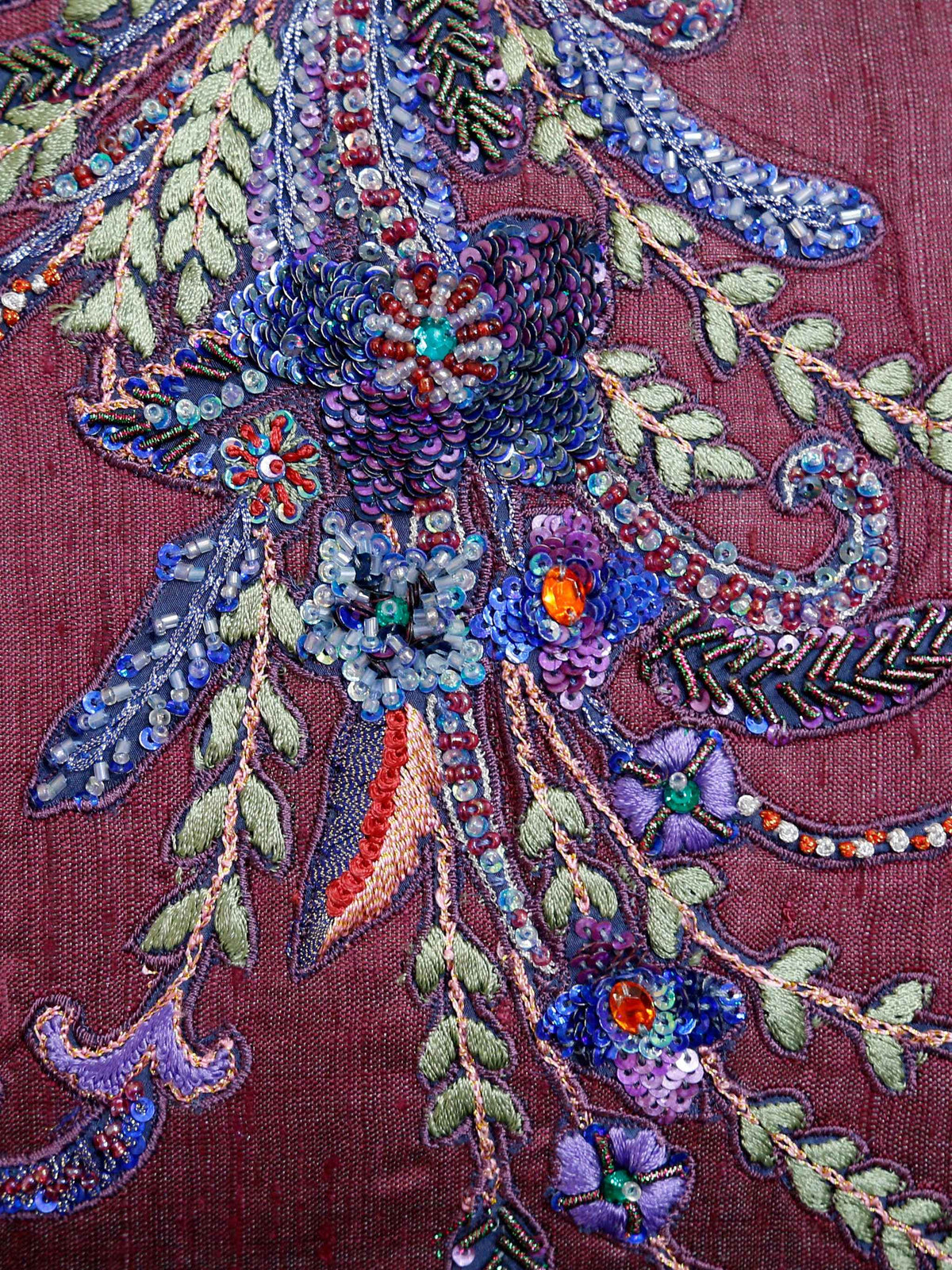 Close up of the beaded and sequinned floral spray on the plum cushion cover