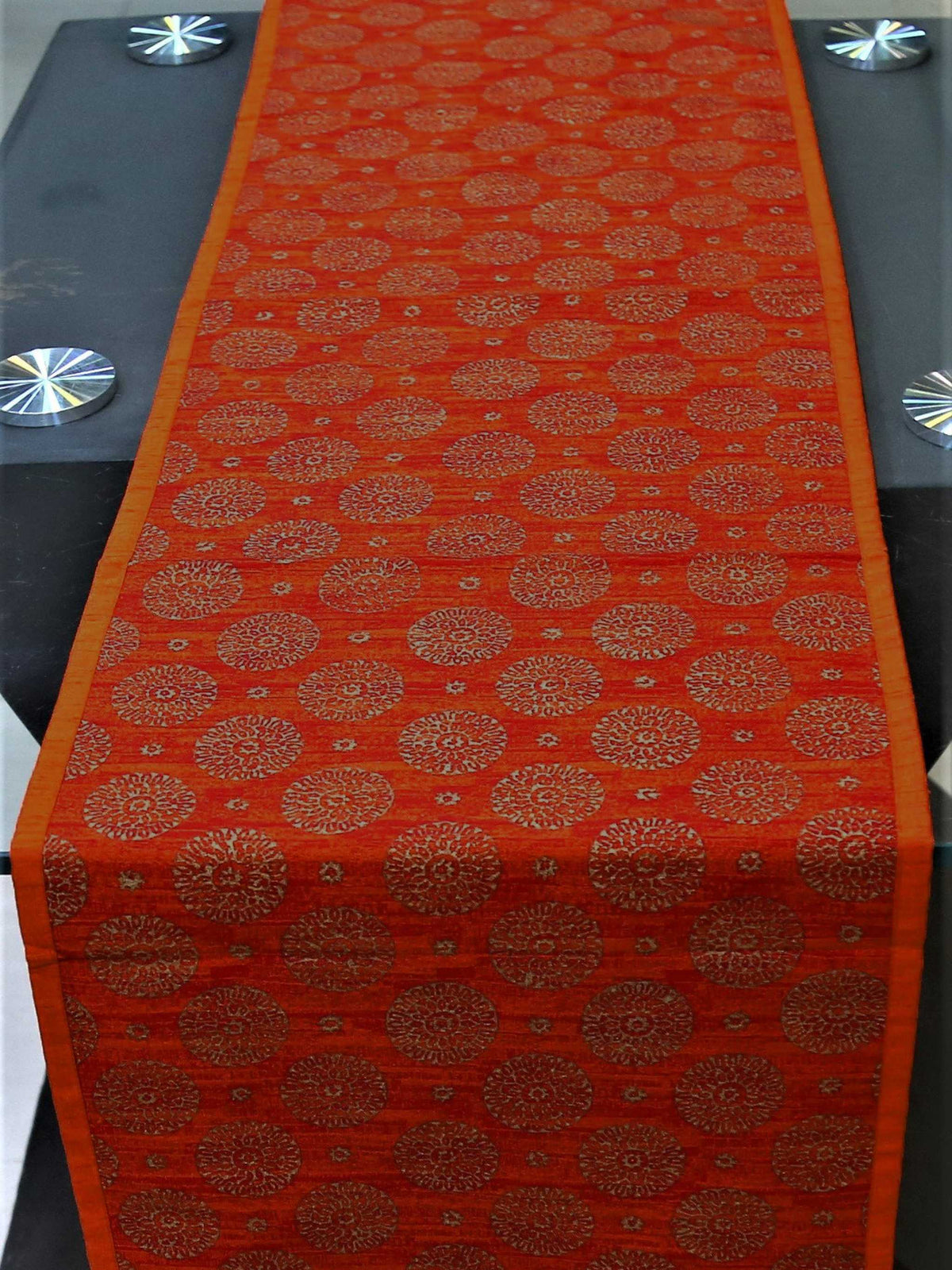 Close view of the rust orange block-printed circle motif on dupion silk