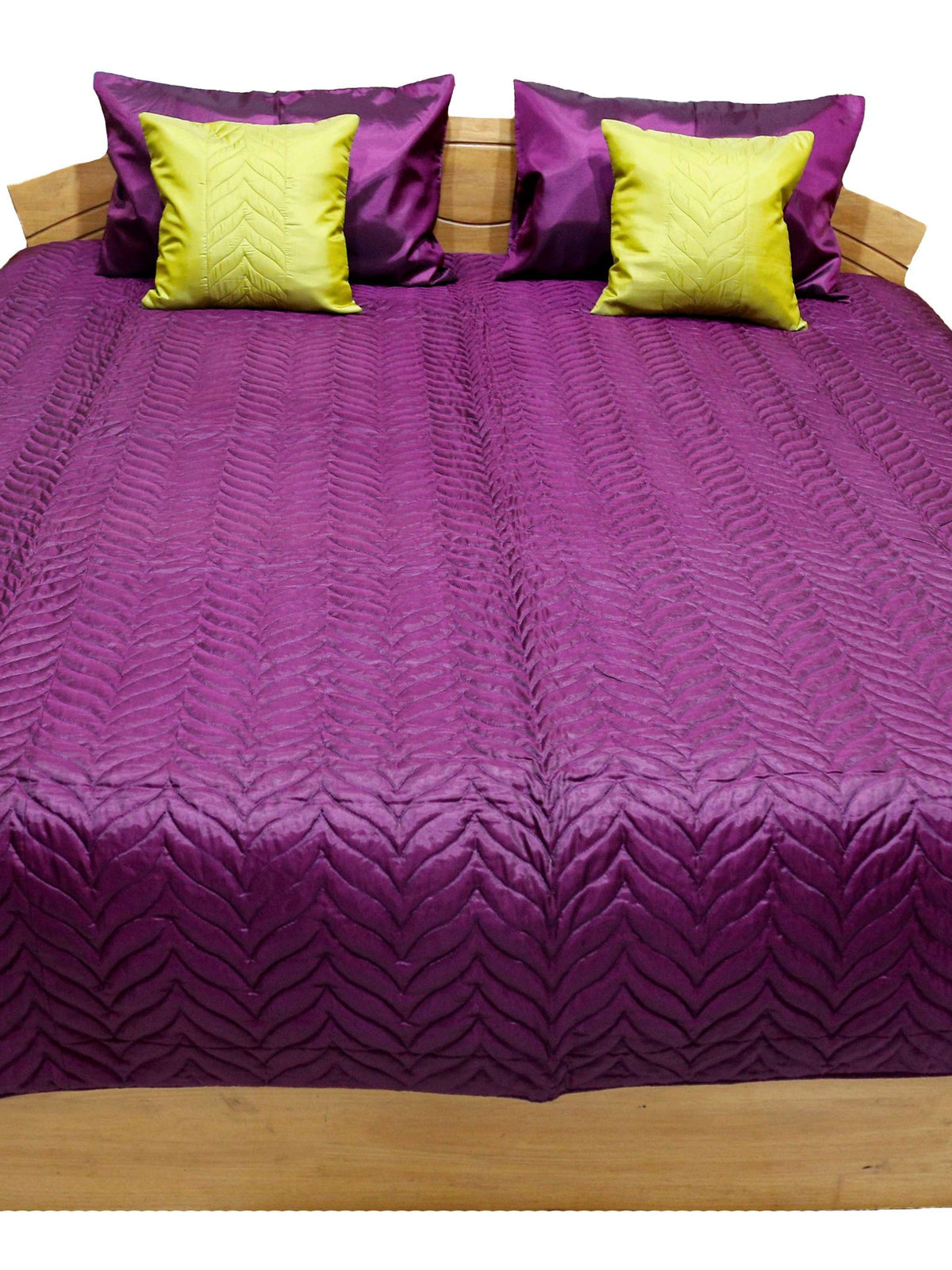 Deep purple embossed quilted double bedcover, angled view showing the chartreuse-yellow cushion covers