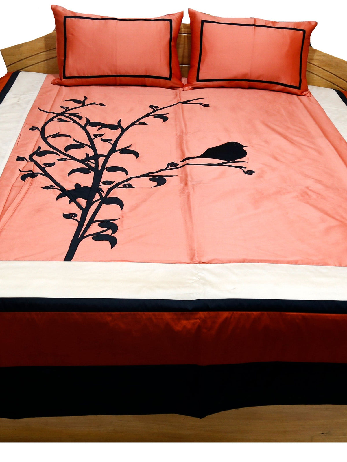 Coral bedcover with black bird and branch applique, rust and black borders