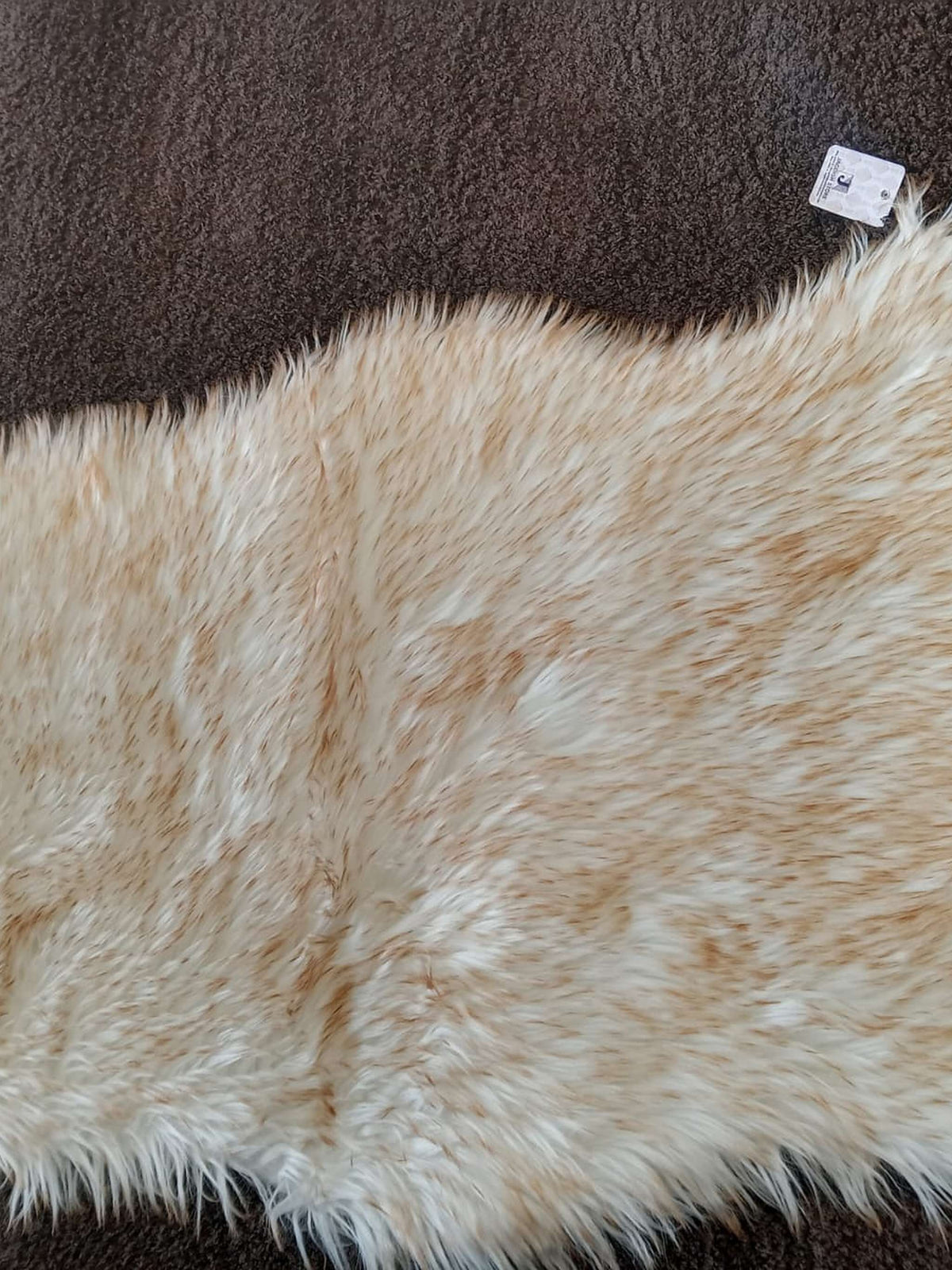 Close view of a blonde faux sheepskin bedside runner's long pile