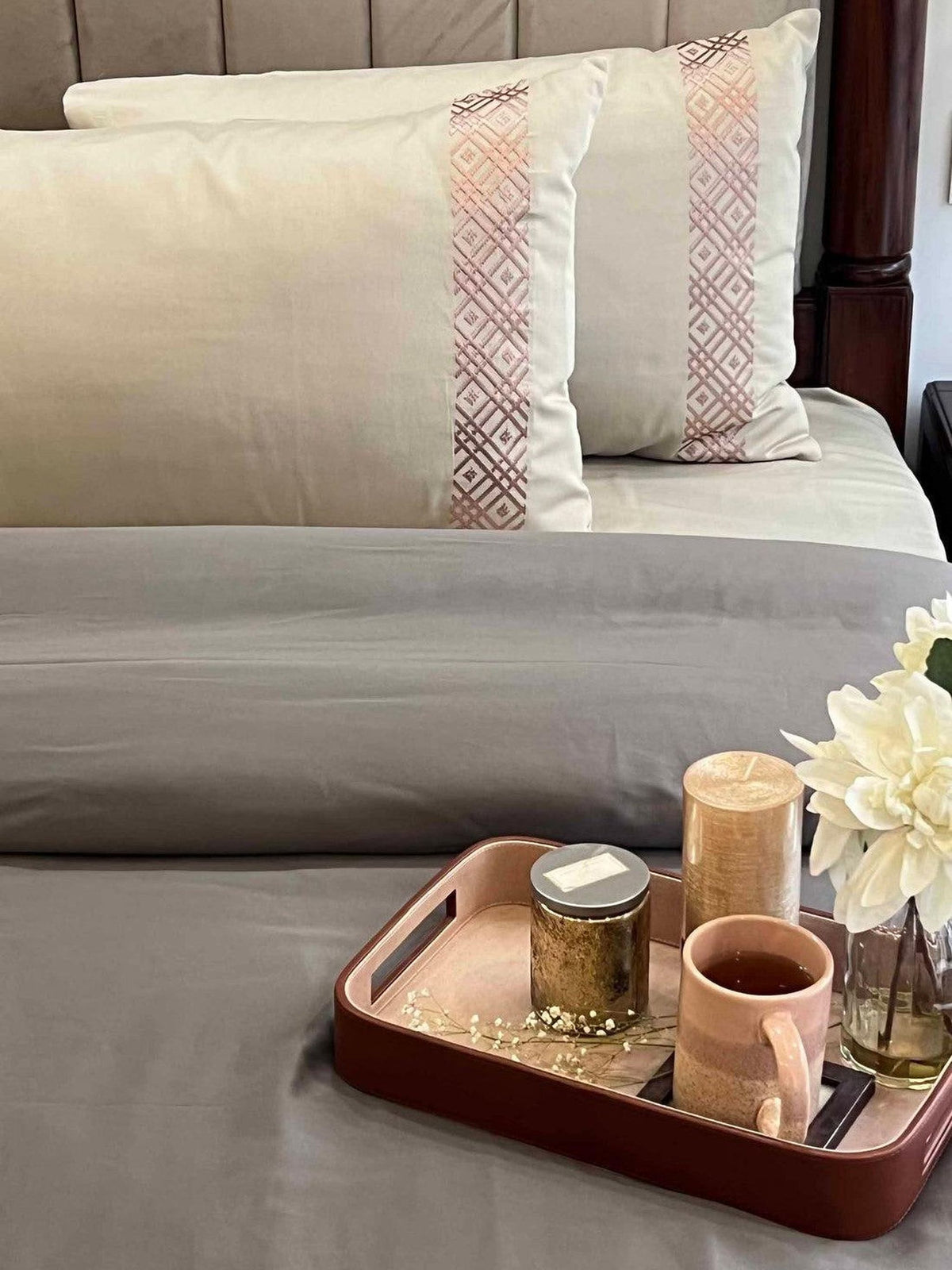 Cream embroidered-band pillows on grey bedding with a tray, Beige Classic Collection