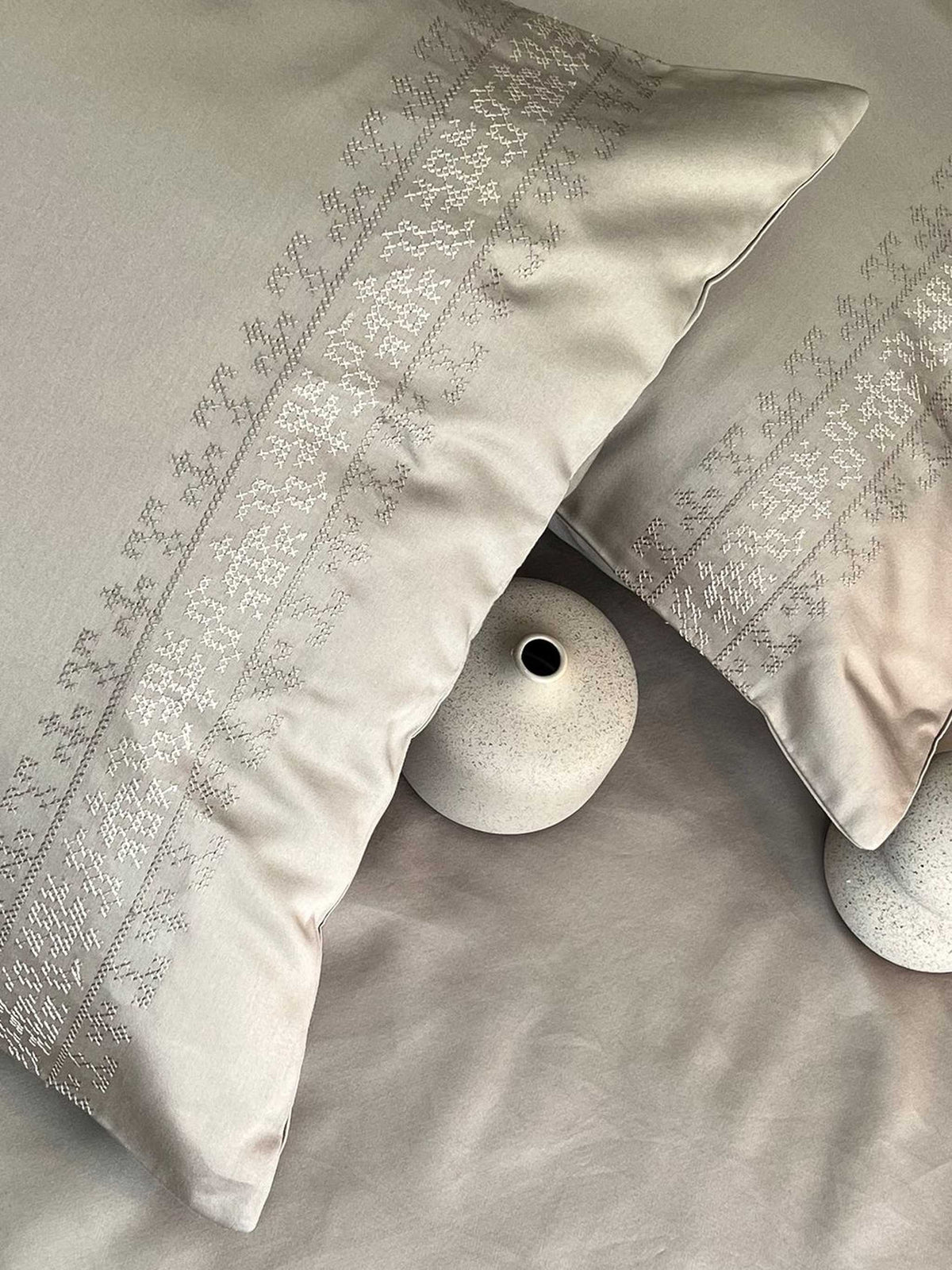 Greige embroidered-band pillows on a made bed, Greige Delight Collection