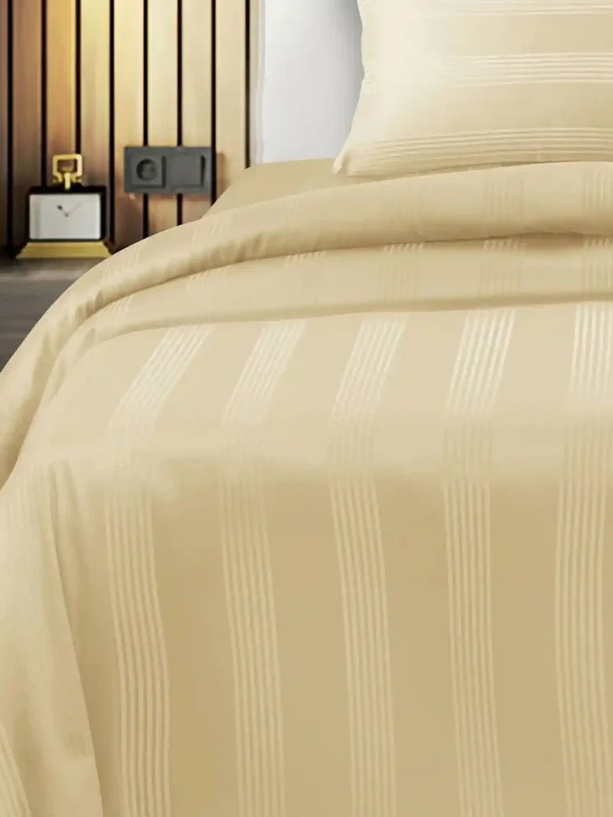 Pale butter cream satin stripe cotton bedsheet draped over a bed