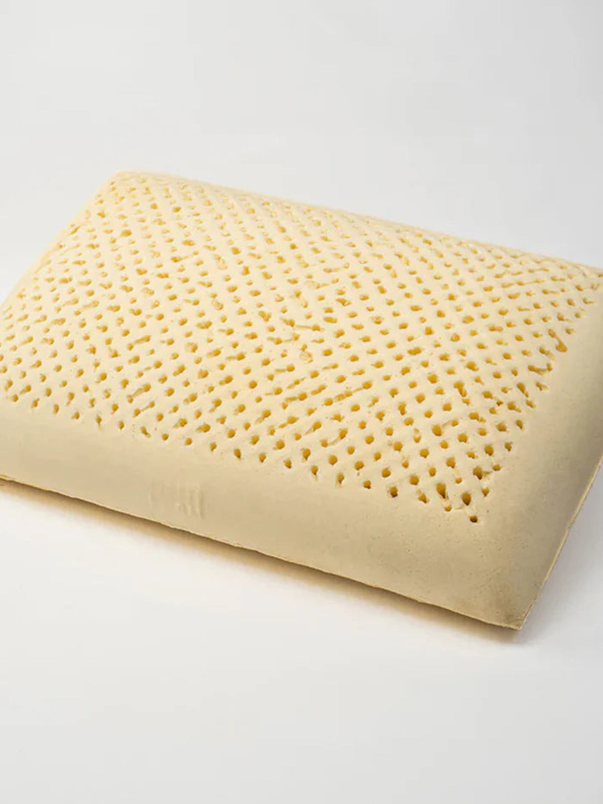 Uncovered natural latex pillow core showing its pincore ventilation holes