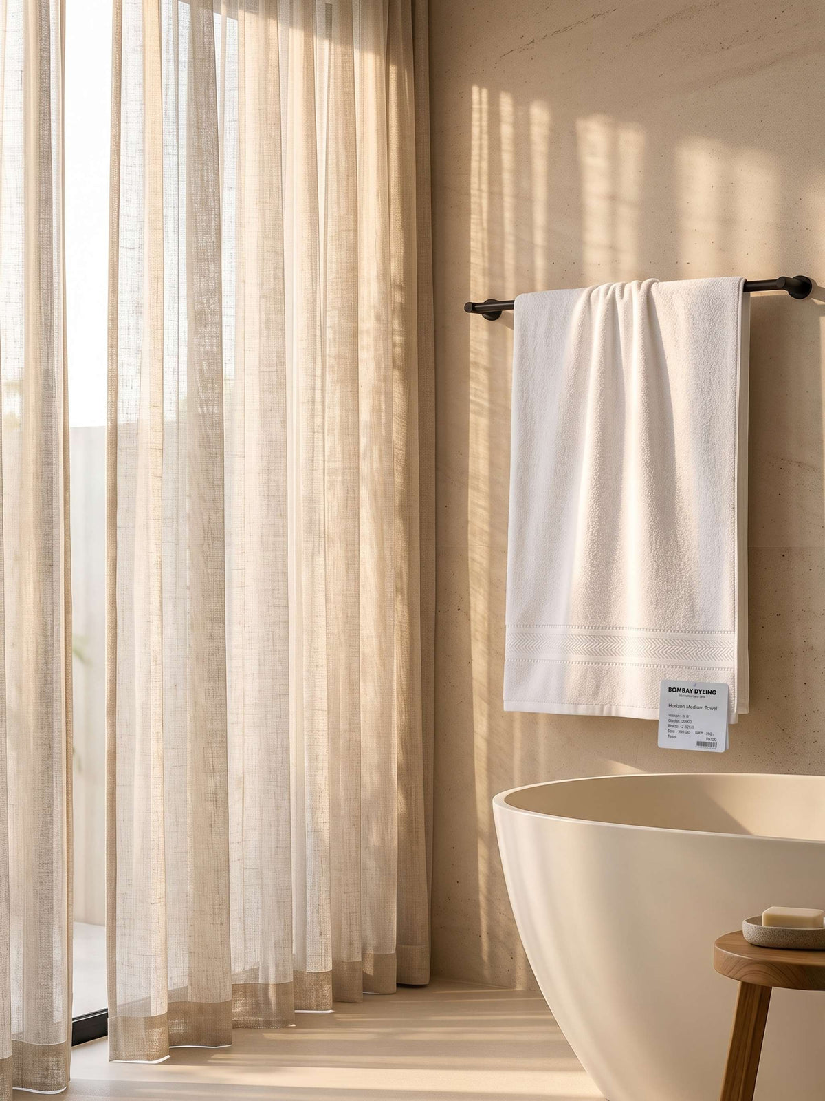 White cotton bath towel with woven border hanging on a bathroom towel bar
