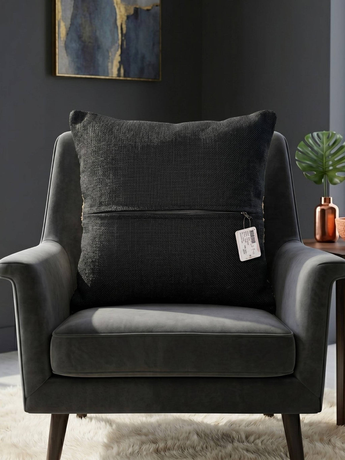 Black textured woven cushion cover with beige geometric detailing placed on a modern armchair