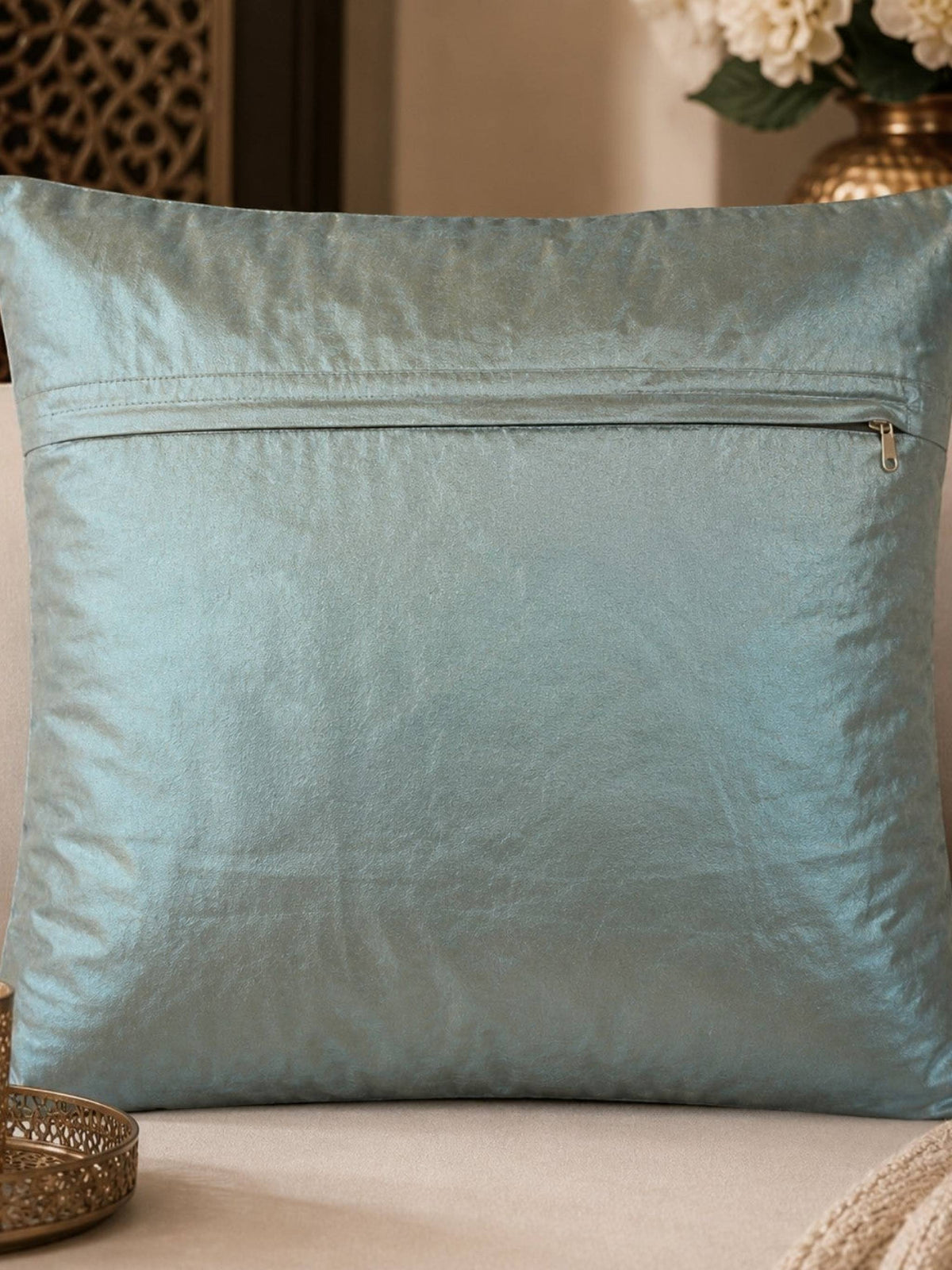 Jagdish Store light blue satin throw pillow cover with copper embroidery, sequins, and turquoise faux gemstones.