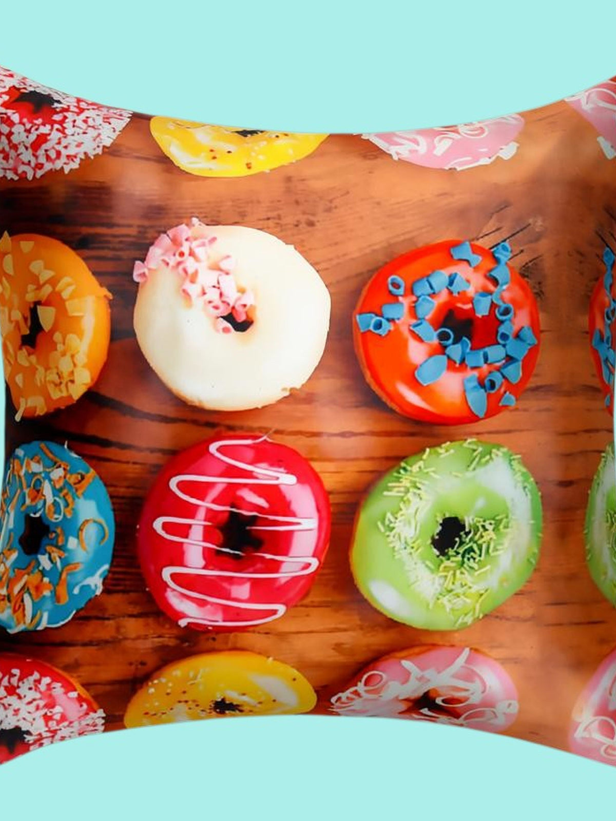 Cushion cover printed with iced doughnuts in bright colours on a wooden background