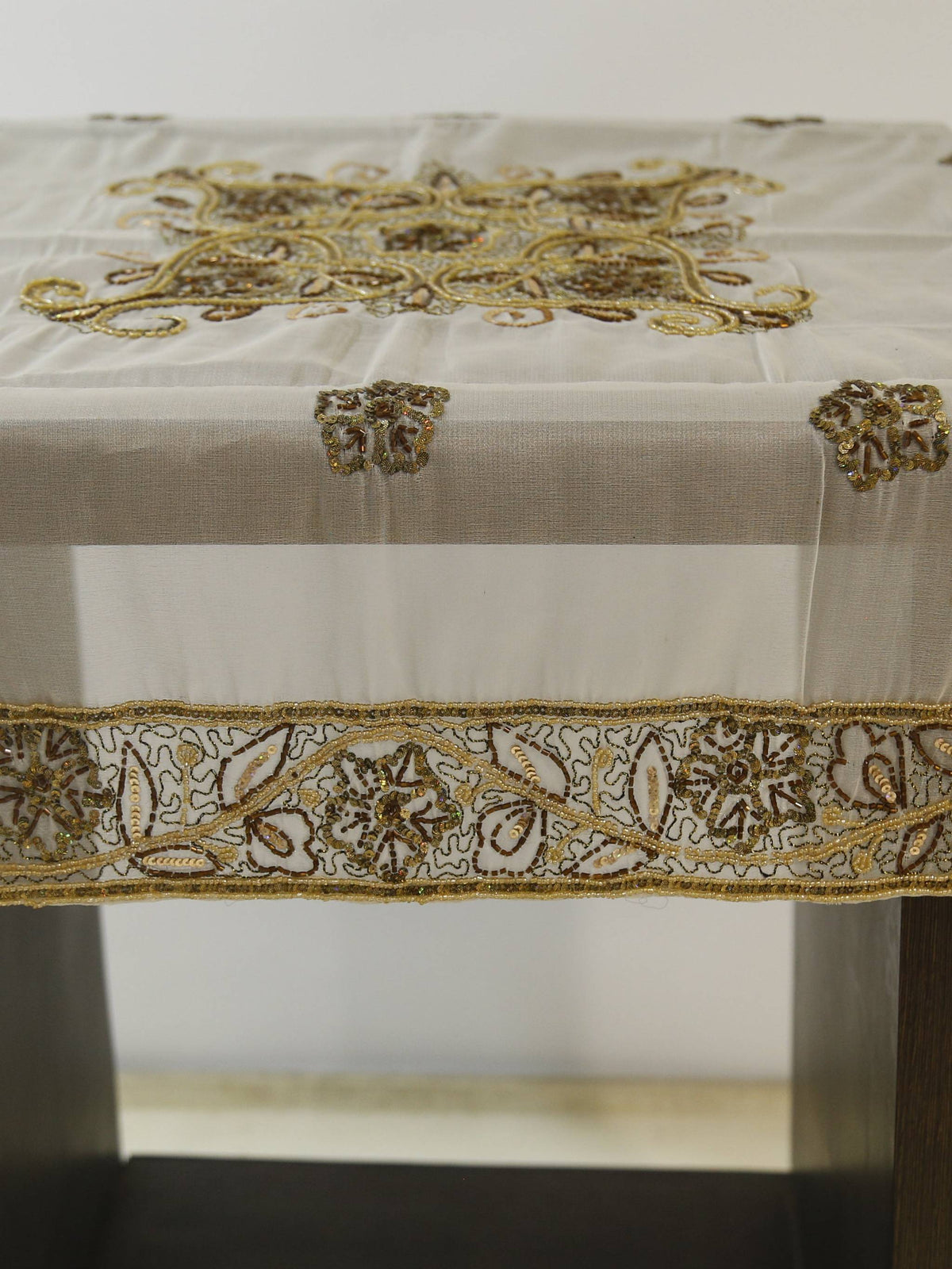 Off-white organza table cover with a gold-beaded floral medallion embroidered at the centre and a scalloped gold-beaded lace border
