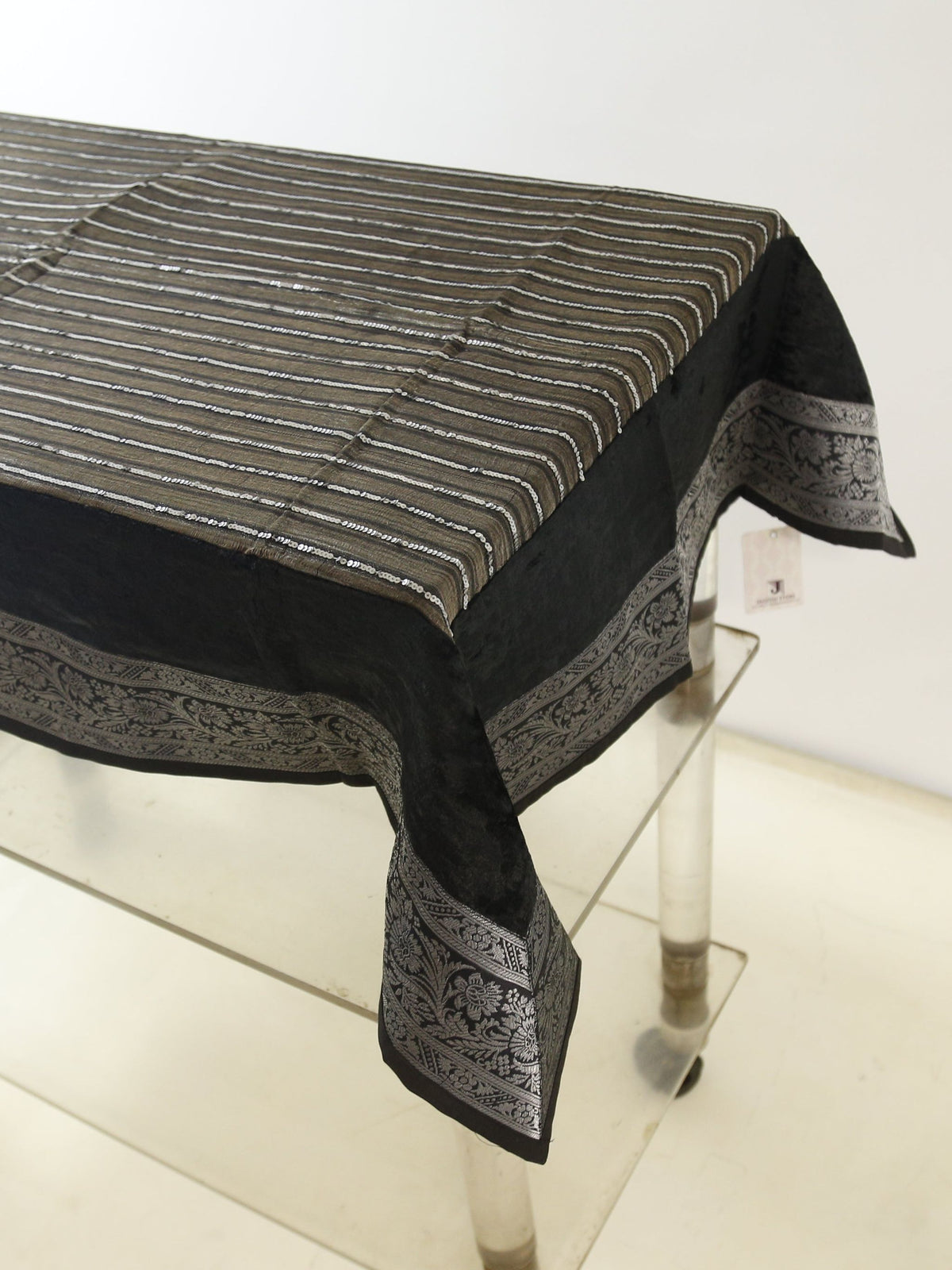 Black velvet table cover with a silver sequinned stripe pattern and a grey-gold floral brocade border