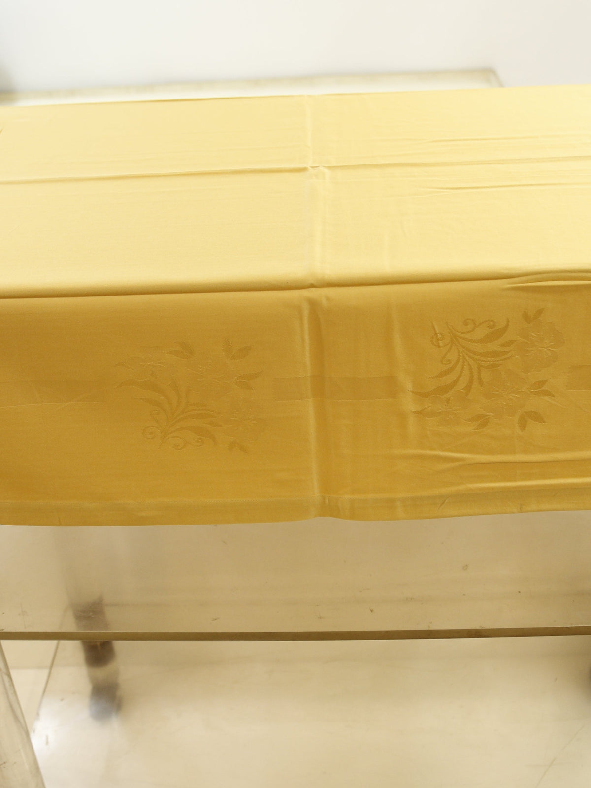 Pale gold self-jacquard table cover with a tone-on-tone floral damask pattern