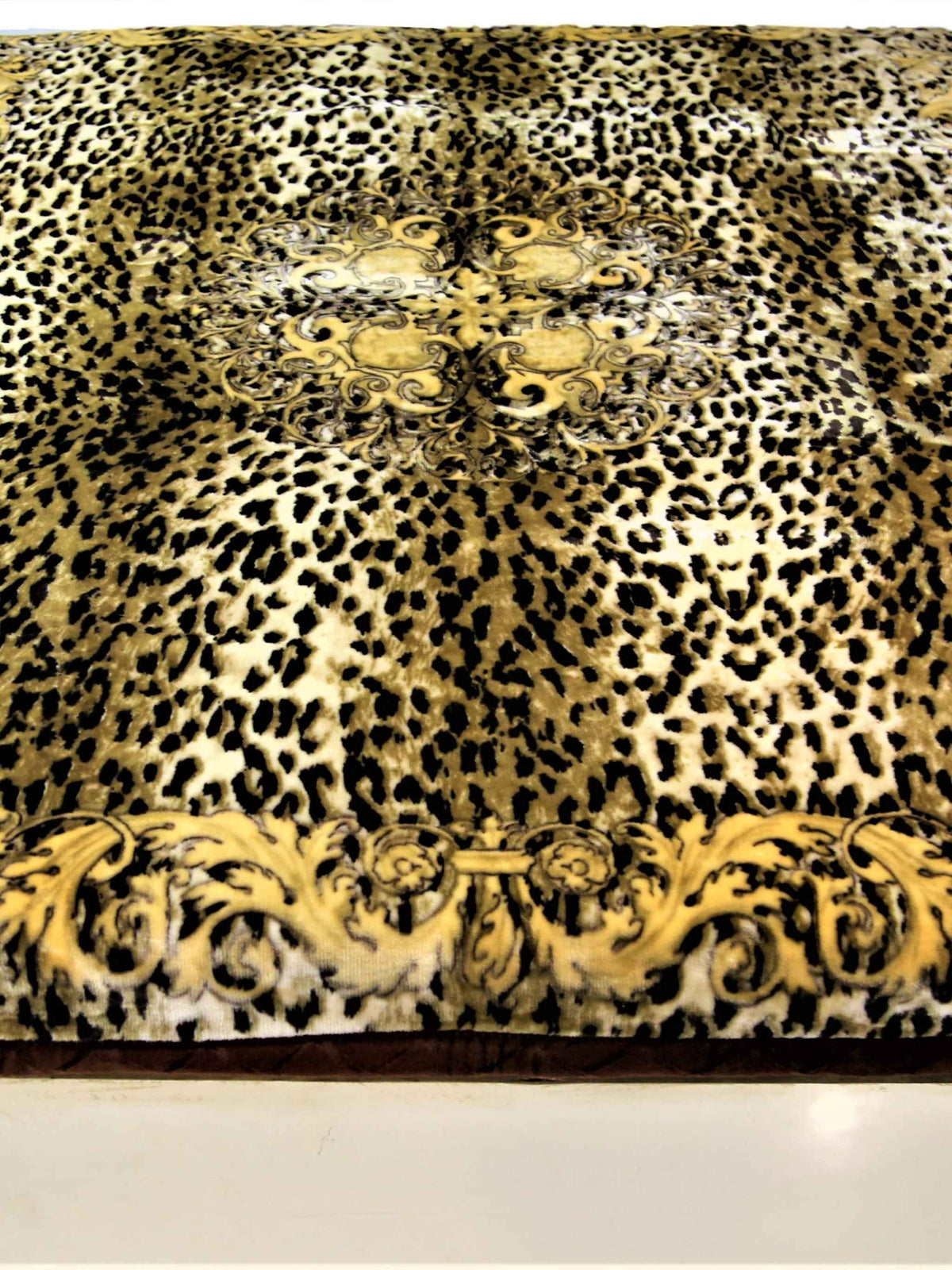 Gold-brown leopard-print blanket with a scroll medallion border