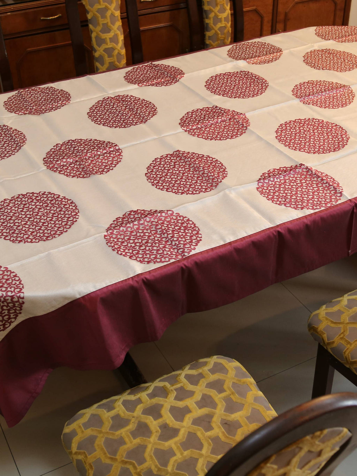 White oval table cover with a maroon circular medallion print and a solid maroon border