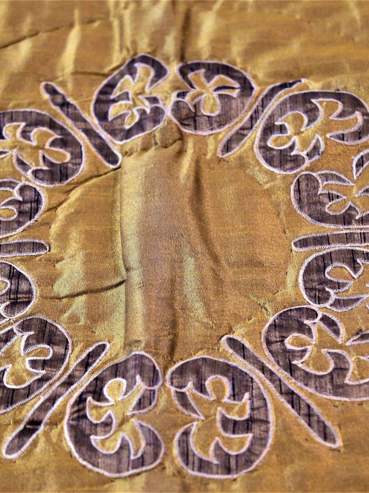 Brown and gold polycotton double bed quilt with striped patchwork panels and scroll embroidery