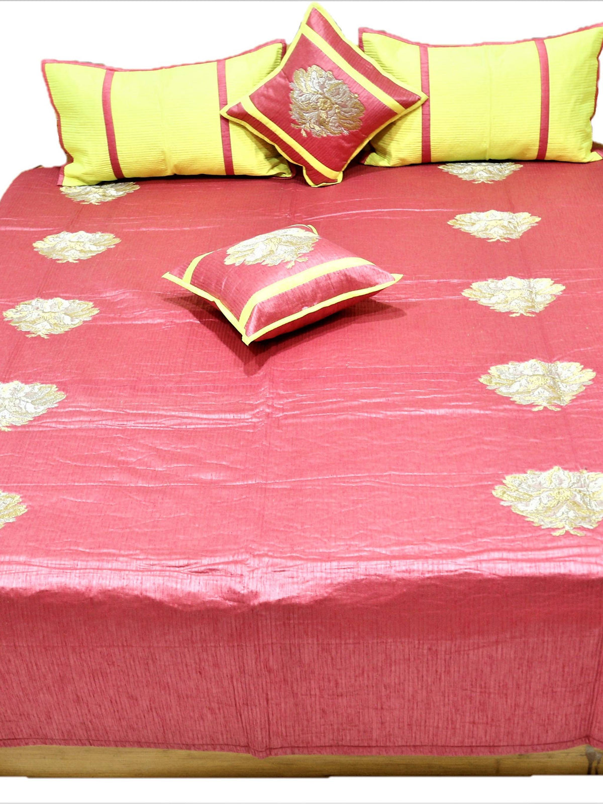 Coral rose bedcover flat view with lemon striped bolsters and maroon zari cushions