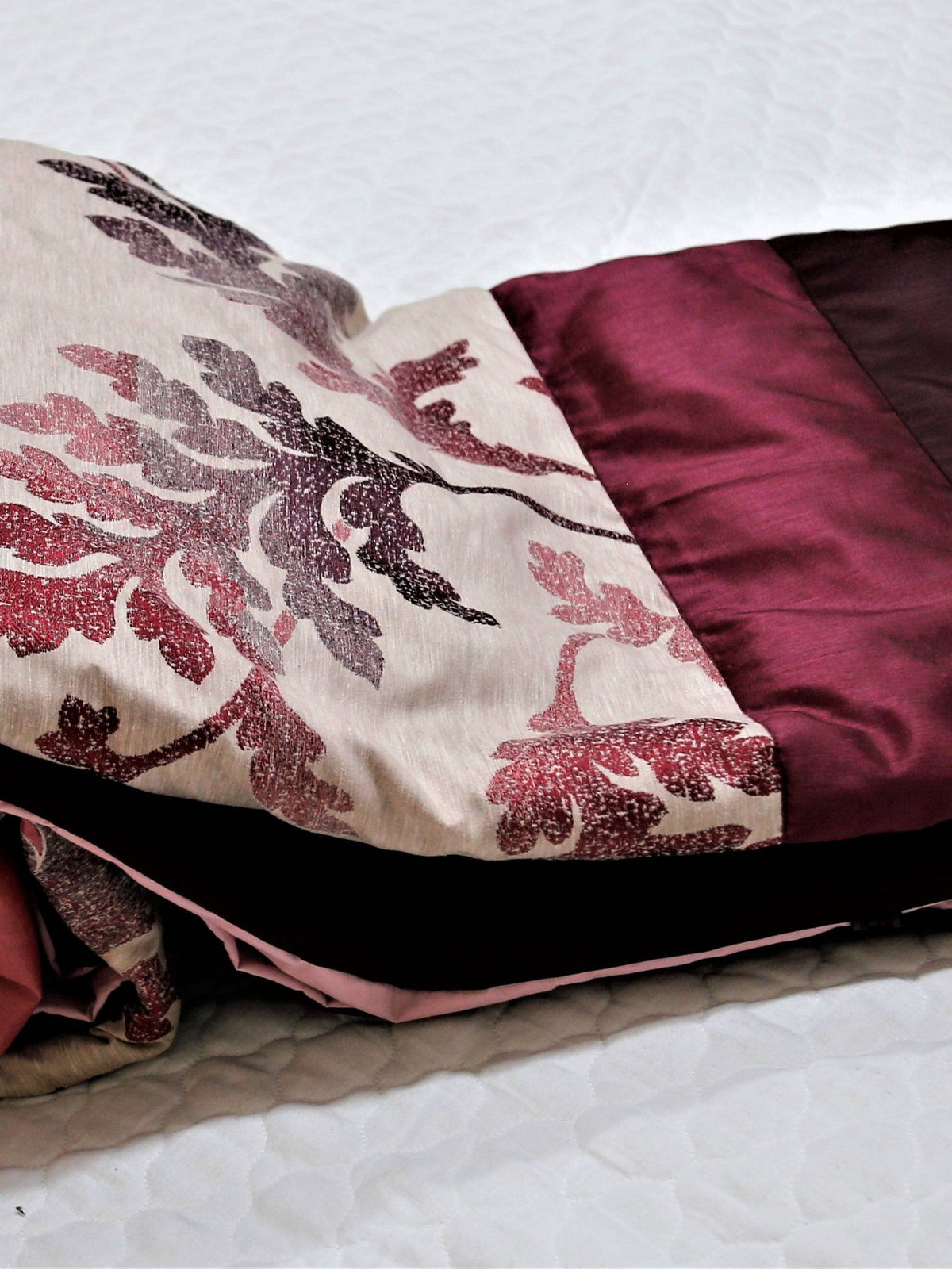 Rose-pink and wine down quilt with watercolour oak-leaf print for a double bed