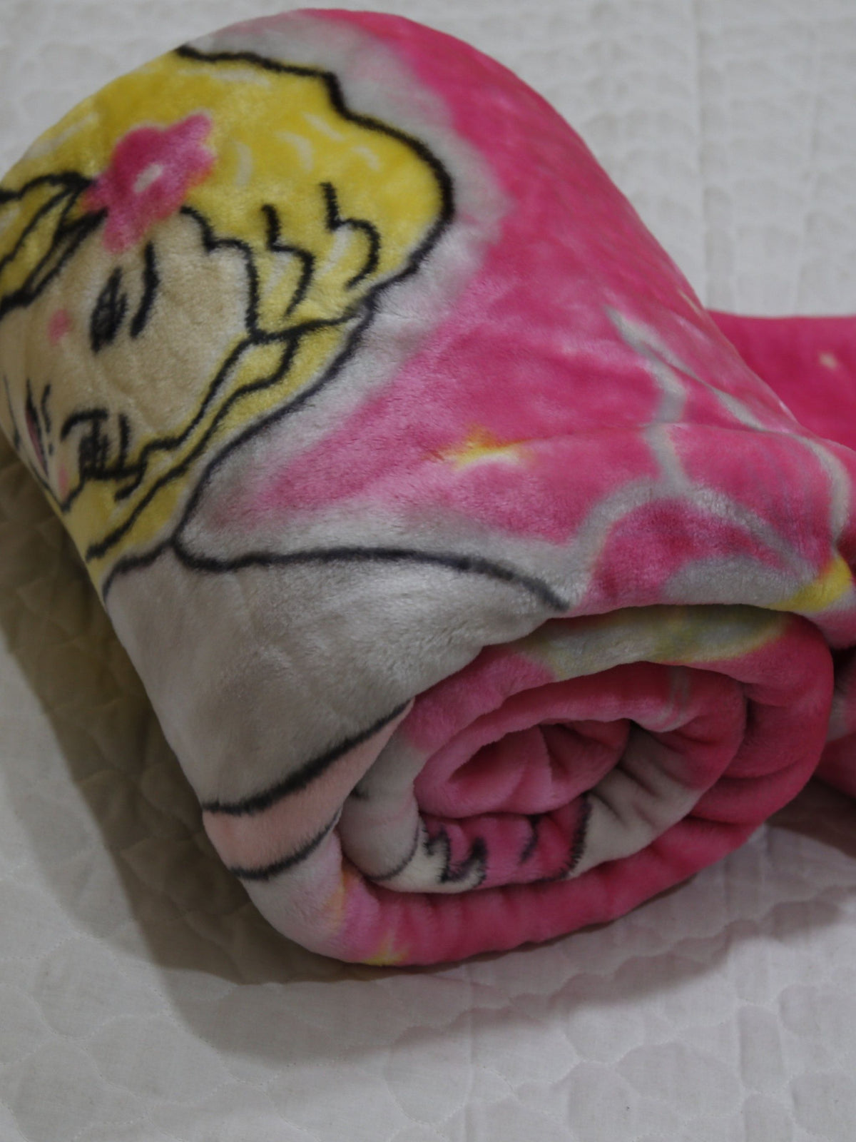 Hot-pink blanket rolled up, showing a close-up of the fairy angel's face