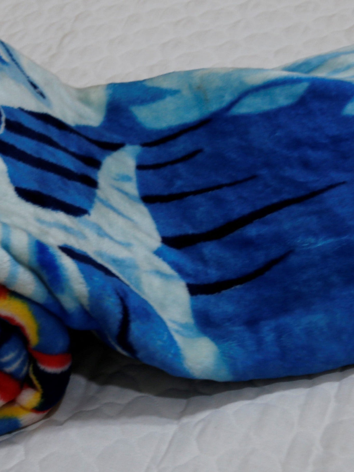 Close-up of the royal-blue blanket's printed underwater coral and wave pattern