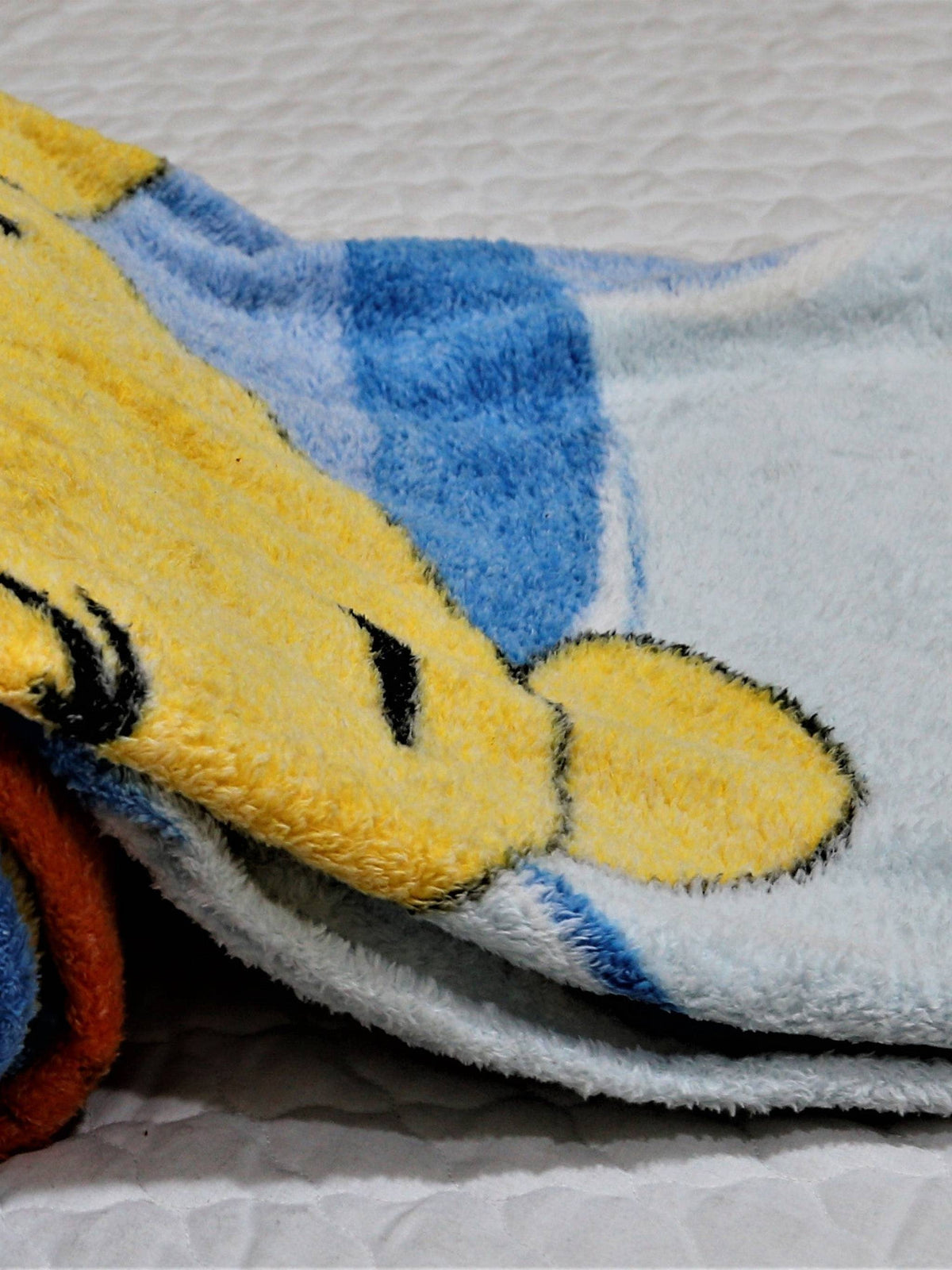Close-up of the blue plush blanket's Winnie the Pooh face print