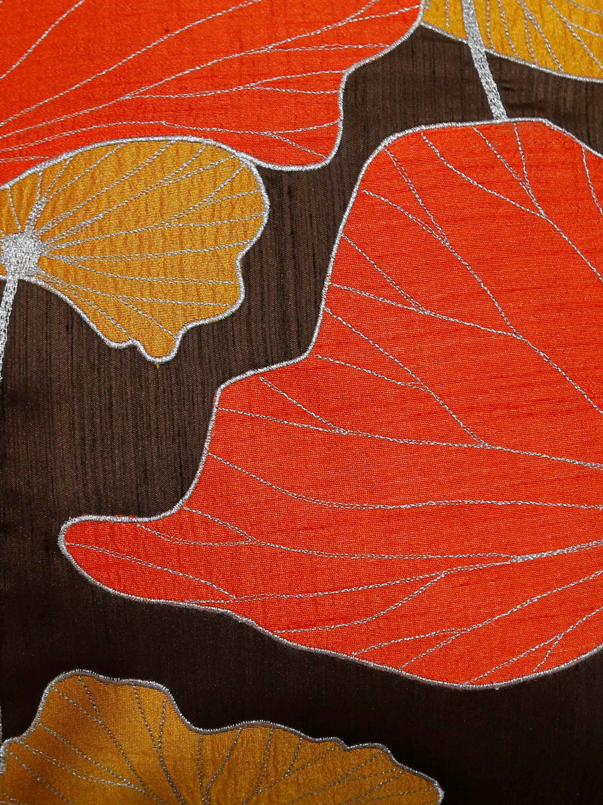 Close up of the orange and gold lotus leaf appliqué on a dark brown ground