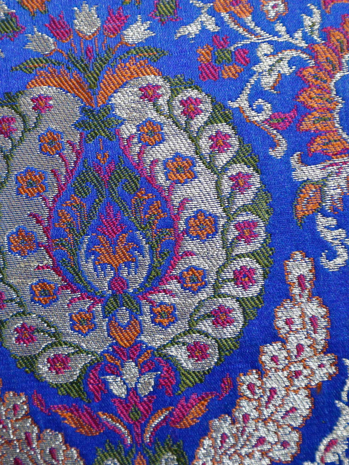 Close up of the royal blue brocade with multicolour woven paisley medallions