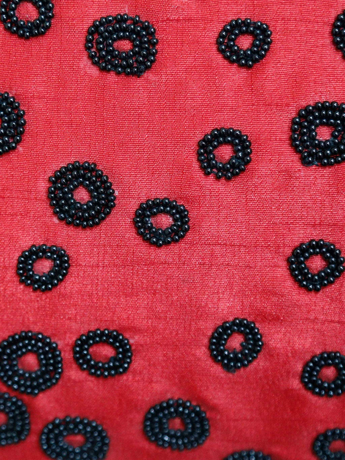 Close up of the black beaded rings worked on the red ground