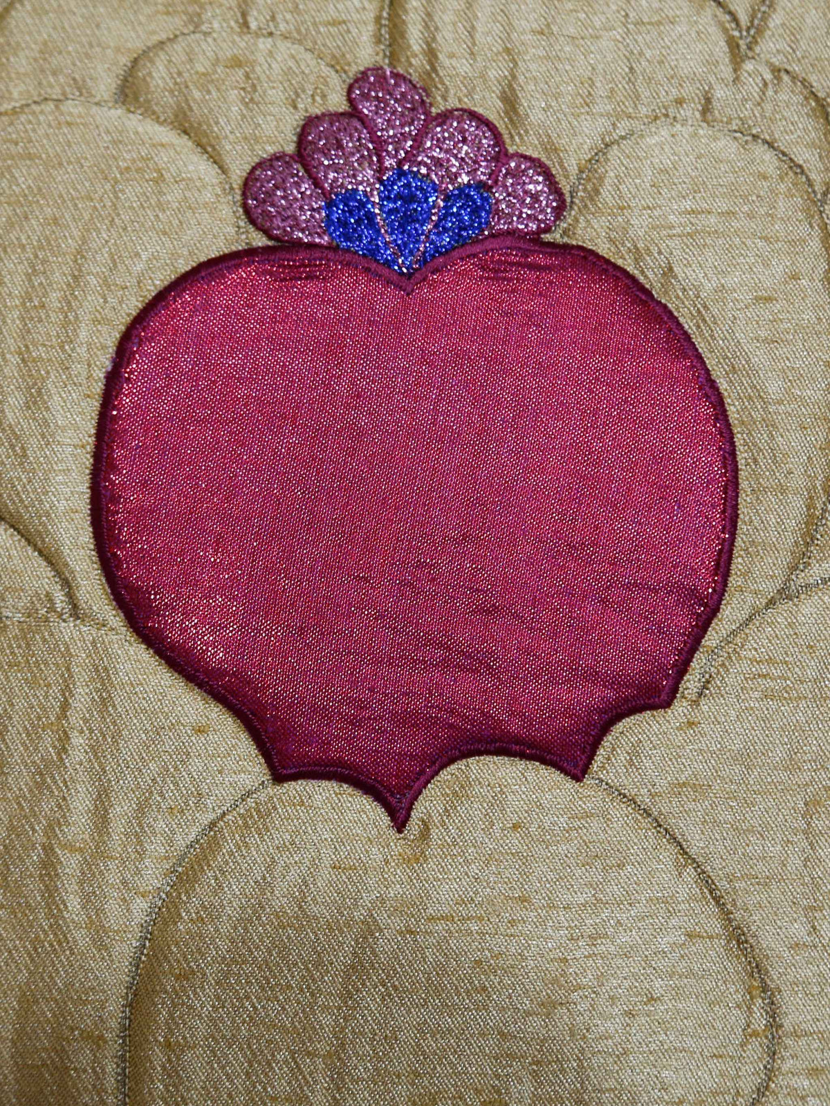 Close-up of the gold lotus appliqué with its beaded pink and blue centre