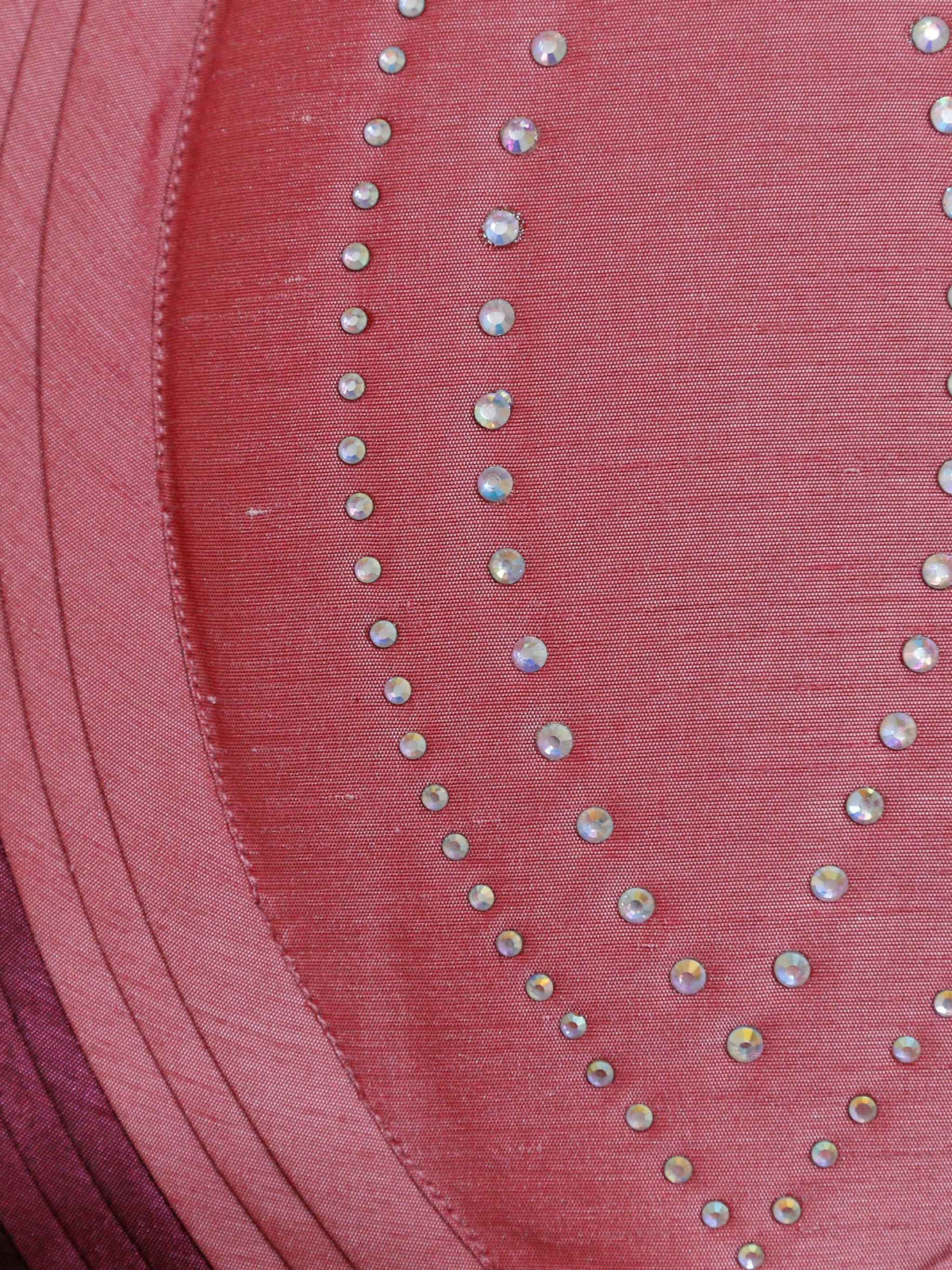Close-up of the coral pink appliqué panels and silver stone work