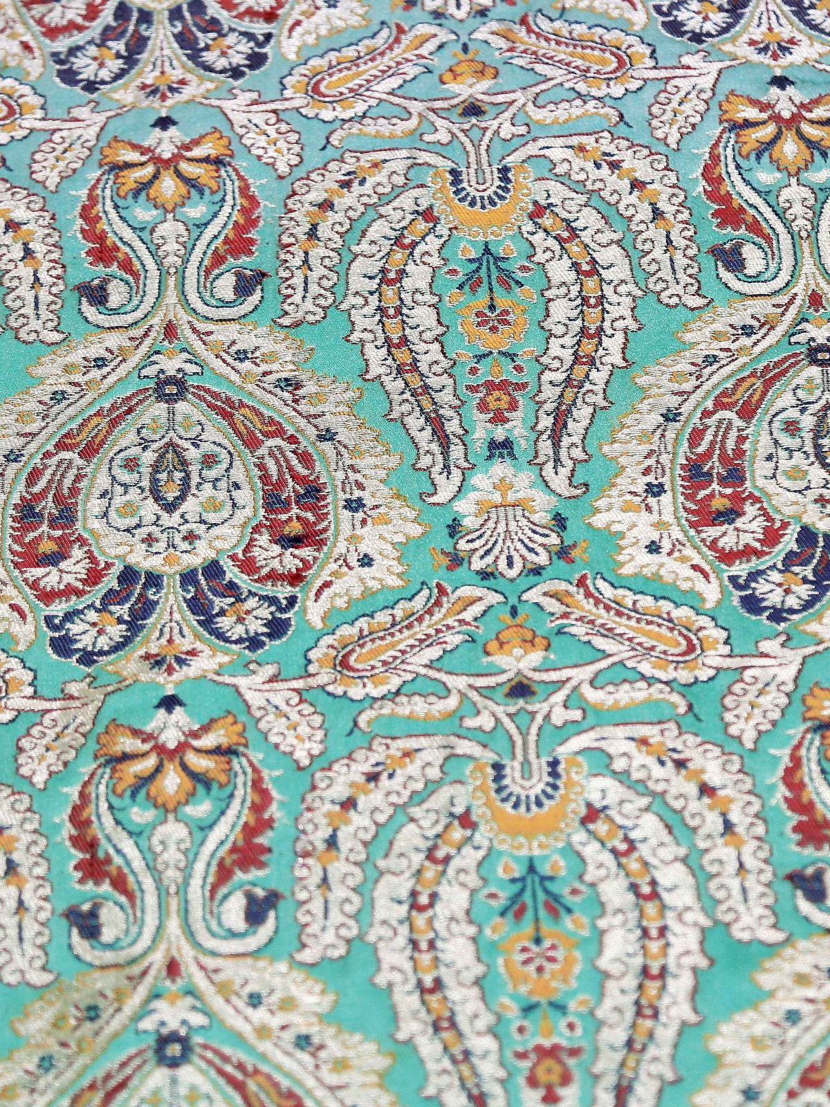 Close-up of turquoise paisley brocade woven in cream, red and gold