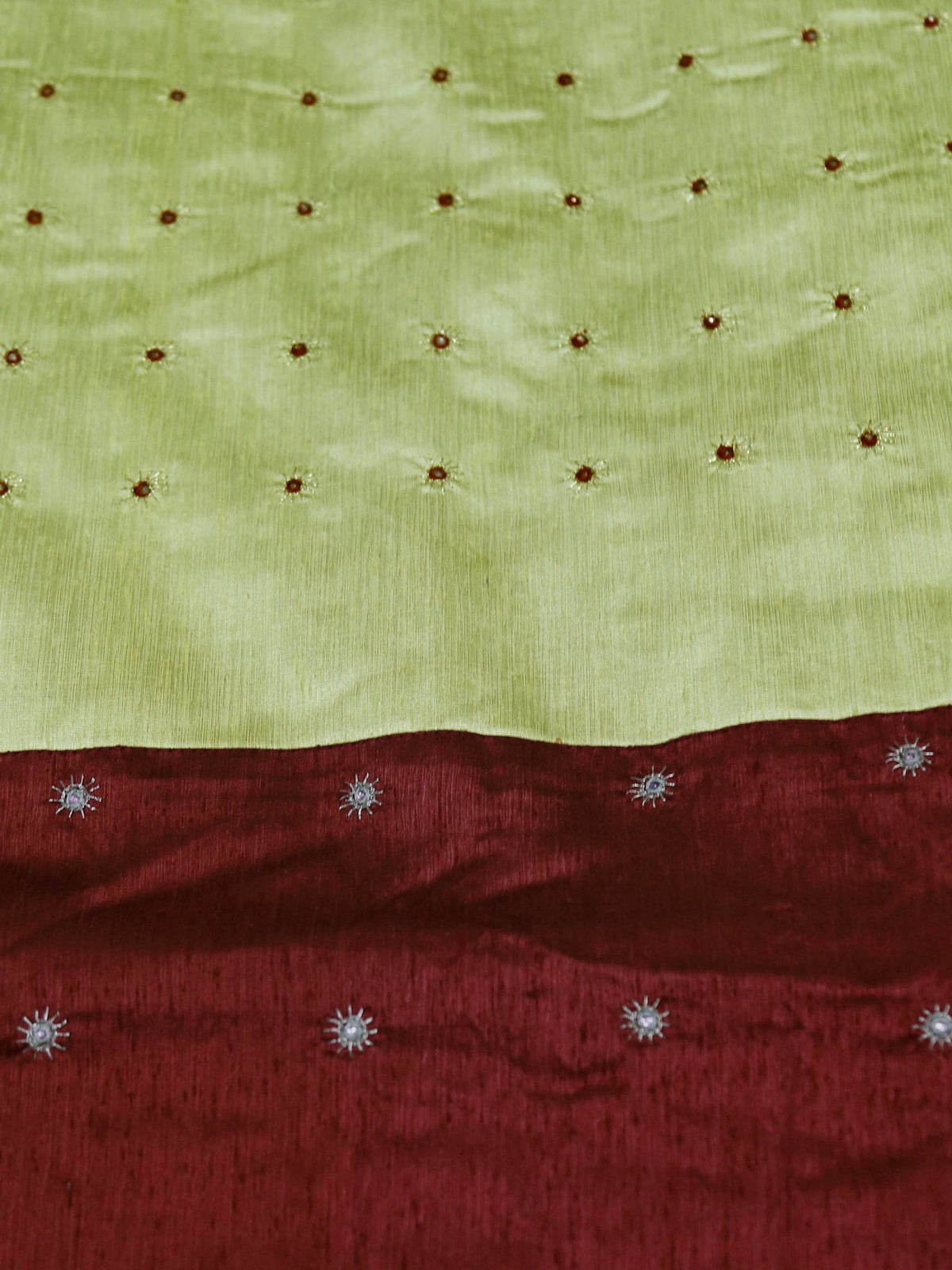 Close-up of gold and silver mirror work dots on pistachio green and maroon silk