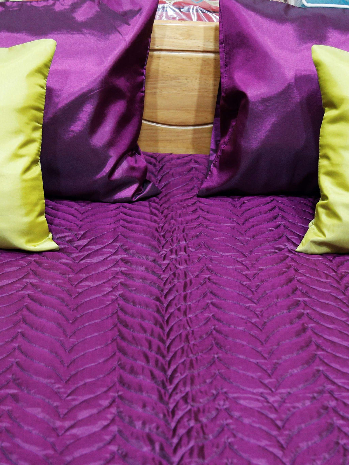 Close-up of the chartreuse-yellow embossed cushion covers against the purple bedcover